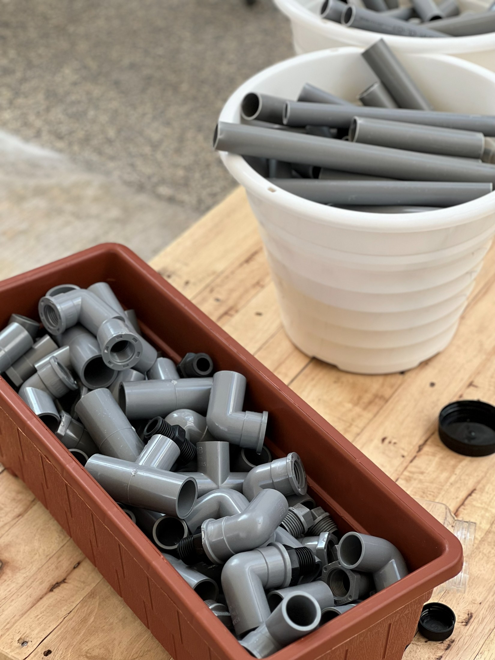 Loose parts and grey pipe materials arranged for open-ended play