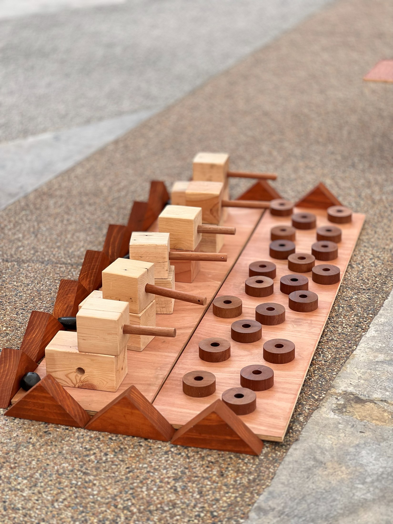 A wooden WE.PLAY loose-parts set arranged for children to explore